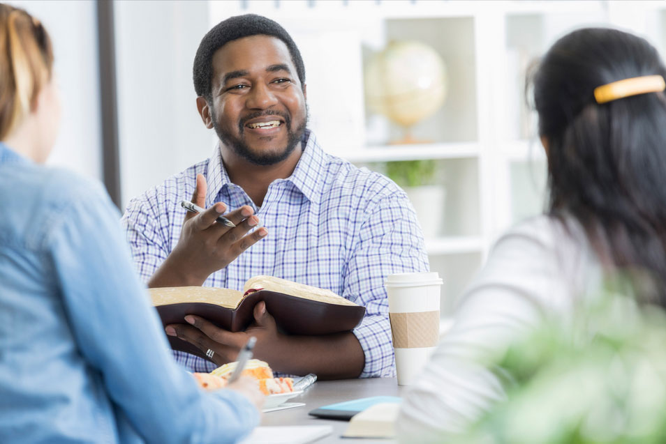 Man and two women in Bible study